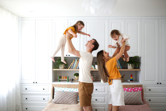 Caucasian family with two children hands in air