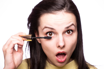 beautiful young girl paints eyelashes