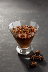 Chocolate mousse with marshmallow in portion glass on black background