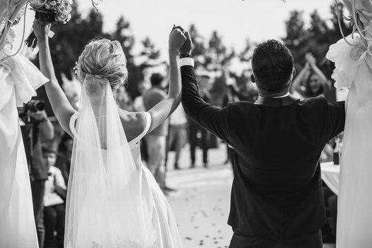 A bride and a groom are celebrating. Black and white image.