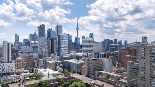 Highest quality cinematic time lapse of fast moving bubbly smooth white clouds and sky. Toronto and its famous architecture and stunning downtown urban architecture skyline.