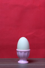 Boiled egg in poached pink. Against the background of coral color.