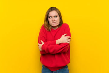 Obraz premium Young woman over yellow wall making doubts gesture while lifting the shoulders