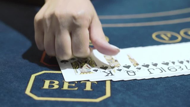 Croupier putting playing cards in row in casino. Playing poker in casino