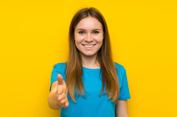 Young woman with blue shirt handshaking after good deal