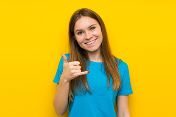 Young woman with blue shirt making phone gesture