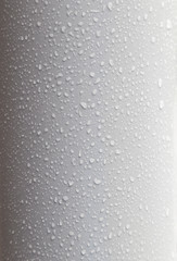 Close-up of waterdrops on a clean, bent and plastic light gray surface. High resolution full frame background.