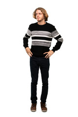 Full-length shot of Blonde man making doubts gesture looking side over isolated white background