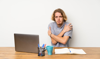 Blonde man with a laptop freezing