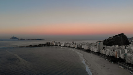 Aerial view of Rio de Janeiro with the Copacabana fort during sunrise showing an empty beach and islands in the background