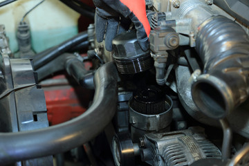 Mechanik wyjmuje obudowę filtr oleju w samochodzie osobowym.