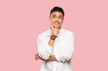 Young man thinking an idea while looking up on colorful background