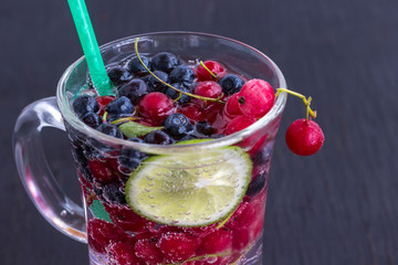 Glass with a cooling drink of berries and ice. Air bubbles on glass
