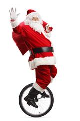 Santa claus riding a unicycle, waving and carrying a sack of presents © Ljupco Smokovski