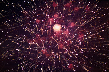 Bright sparkling fireworks, red-white, with haze, in the night sky