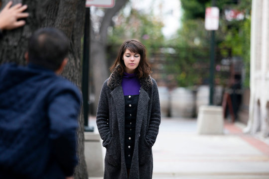 Man Being Rude, Leering And Cat Calling Or Sexually Harassing A Woman Walking On The Street.  Also Depicts Crime And Safety With A Stalker Following A Female Victim.