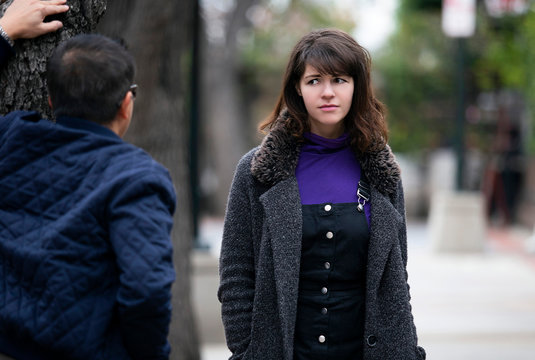 Man being rude, leering and cat calling or sexually harassing a woman walking on the street.  Also depicts crime and safety with a stalker following a female victim.