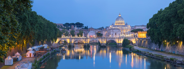 Panorama of Rome landmarks with bridge and Cathedral Saint Peter in evening lights 