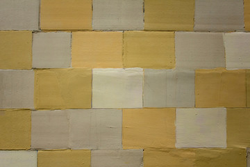 old wall of white yellow and gray tiles. rough surface texture