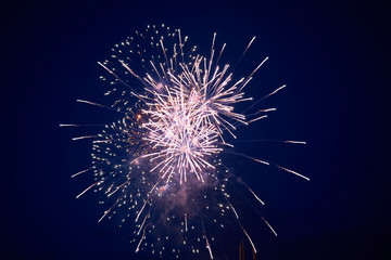 Cheap bright sparkling fireworks, pink, with haze, on the night sky, background texture