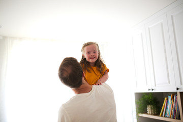 Young dad holding daughter with Down syndrome