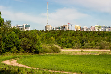 Fototapeta premium View of the modern urban development from a distance from the forest and fields. Obninsk, Russia - May 2019