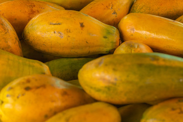 Papaya in the market. Fruit of orange pulp with countless small seeds. Exotic tropical fruit