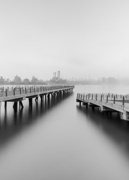 View on Two piers on East River on a foggy morning with long exposure, black and white photo