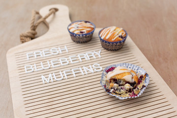 Freshly baked homemade blueberry muffins on a letterboard that says 