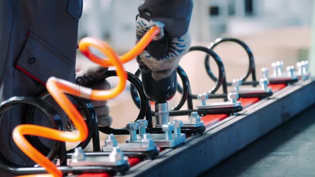 Tightening nuts with pneumatic wrench in workshop of assembly. Clamping nuts