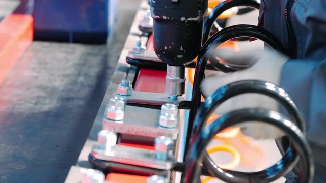 Mechanic working with pneumatic wrench during process of assembly of unit