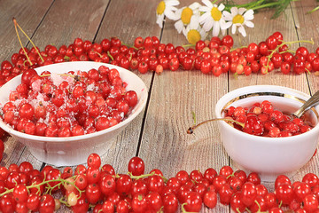 Red currant on a wooden light background, selective focus.