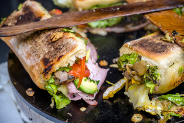 Appetizing Sandwiches with crispy bread and organic vegetables and cheese and ham and spices are baked on the plate