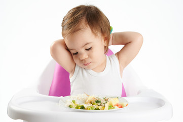 Obraz na płótnie Canvas Bored baby girl with food