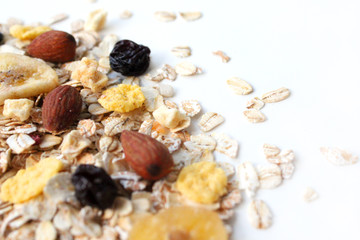 Dry oatmeal. Oatmeal with nuts, cornflakes and raisins on white background.