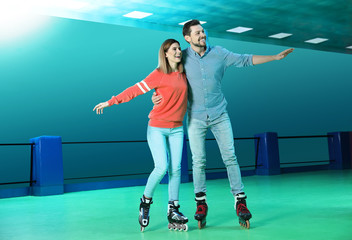 Happy couple having fun at roller skating rink