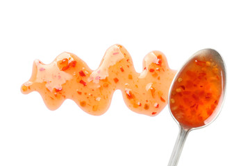 Delicious sweet chili sauce and spoon on white background, top view
