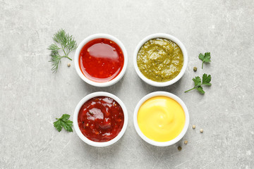 Obraz na płótnie Canvas Set of different delicious sauces on grey table, top view