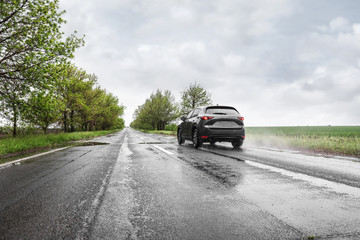 Wet suburban road with car on rainy day