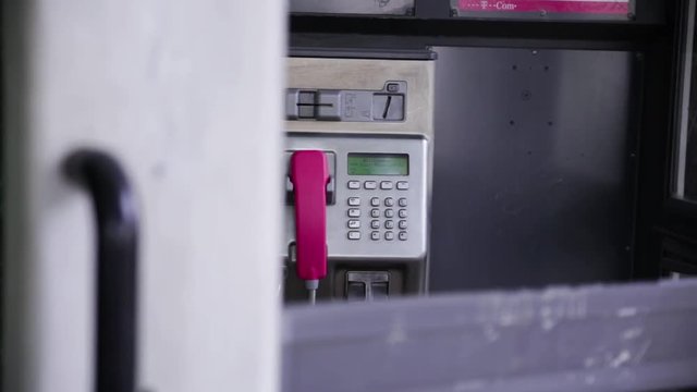 video film historische Telefon Telekom alte silberne telefonzelle mit roter r&ouml;hre und telekommunikations telefon zelle an der wand des vergangenen 20. jahrhunderts