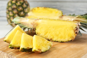 Cut fresh juicy pineapple on wooden board, closeup