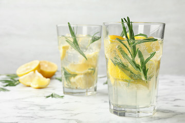 Glasses of refreshing lemonade on marble table, space for text. Summer drink