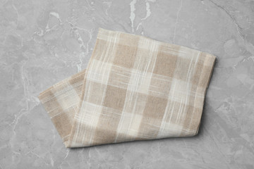 Folded kitchen towel on grey stone table, top view