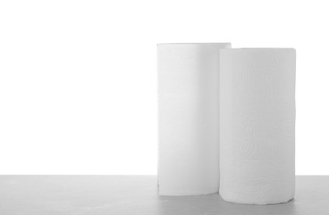 Rolls of paper towels on grey stone table against white background, space for text