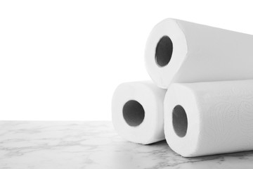 Rolls of paper towels on grey stone table against white background, space for text