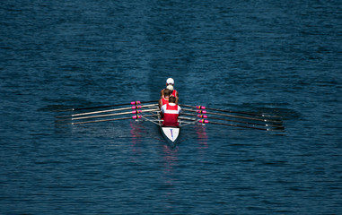 Four Male Rowers In A Quad Racing Boat With Synchronous Oar Stroke