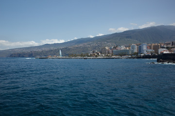 Puerto de la Cruz, Tenerife - April 12, 2017: view of the townscape and the coastline on a sunny day. Fountains of Lago Martianez - famous place for tourists and local people. Wide angle panorama