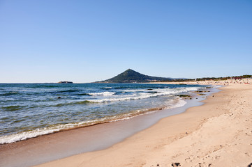 Moledo beach on a spring day, with waves on the sea and a mountain in the background