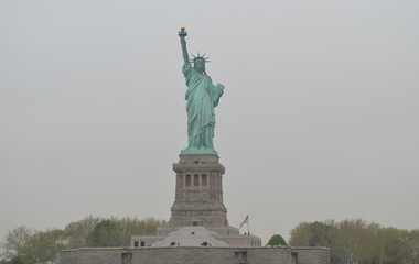 Fototapeta premium Statue of Liberty (American Flag to the right) on an Overcast Spring Morning
