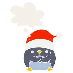 cute cartoon penguin wearing christmas hat and thought bubble in retro style